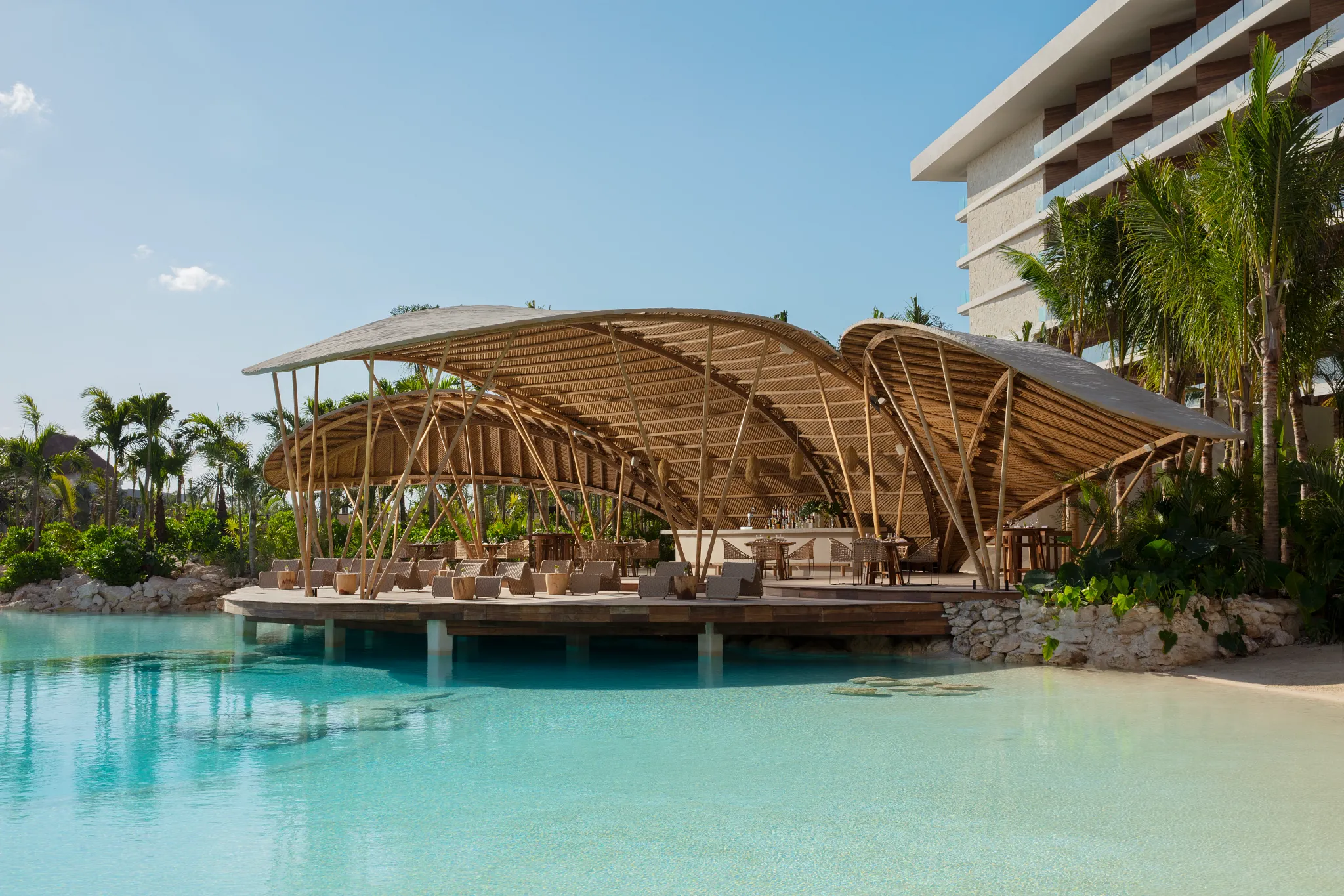 Bamboo restaurant at Secrets Moxché Playa del Carmen featuring an open-air bamboo structure overlooking a turquoise lagoon-style pool.