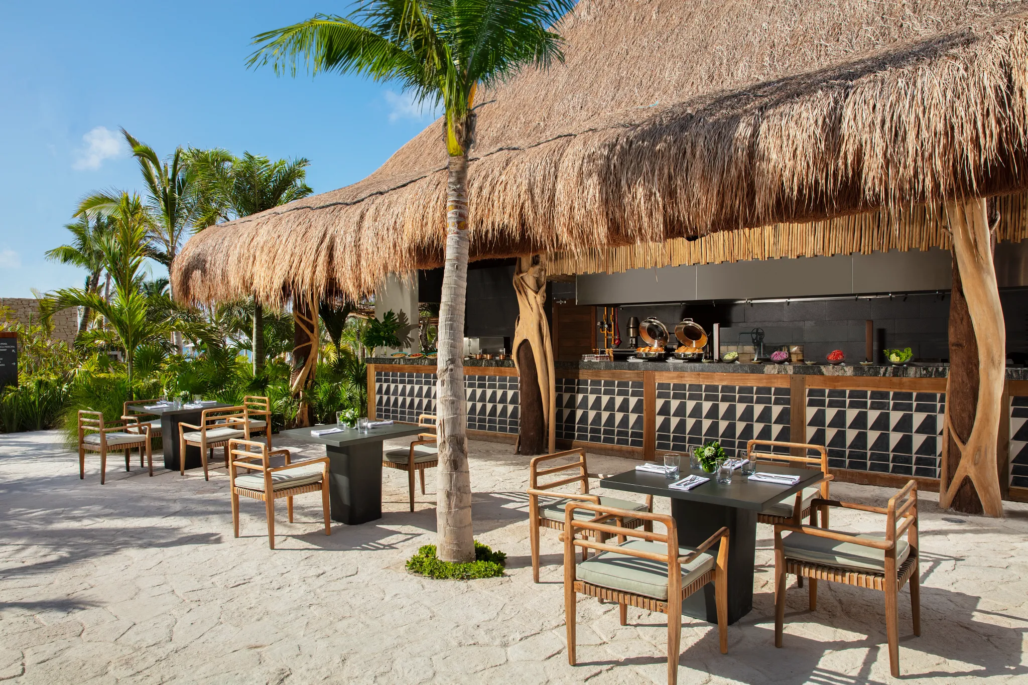 Barefoot Grill at Secrets Moxché Playa del Carmen featuring a thatched-roof outdoor dining area with casual seating and tropical surroundings.