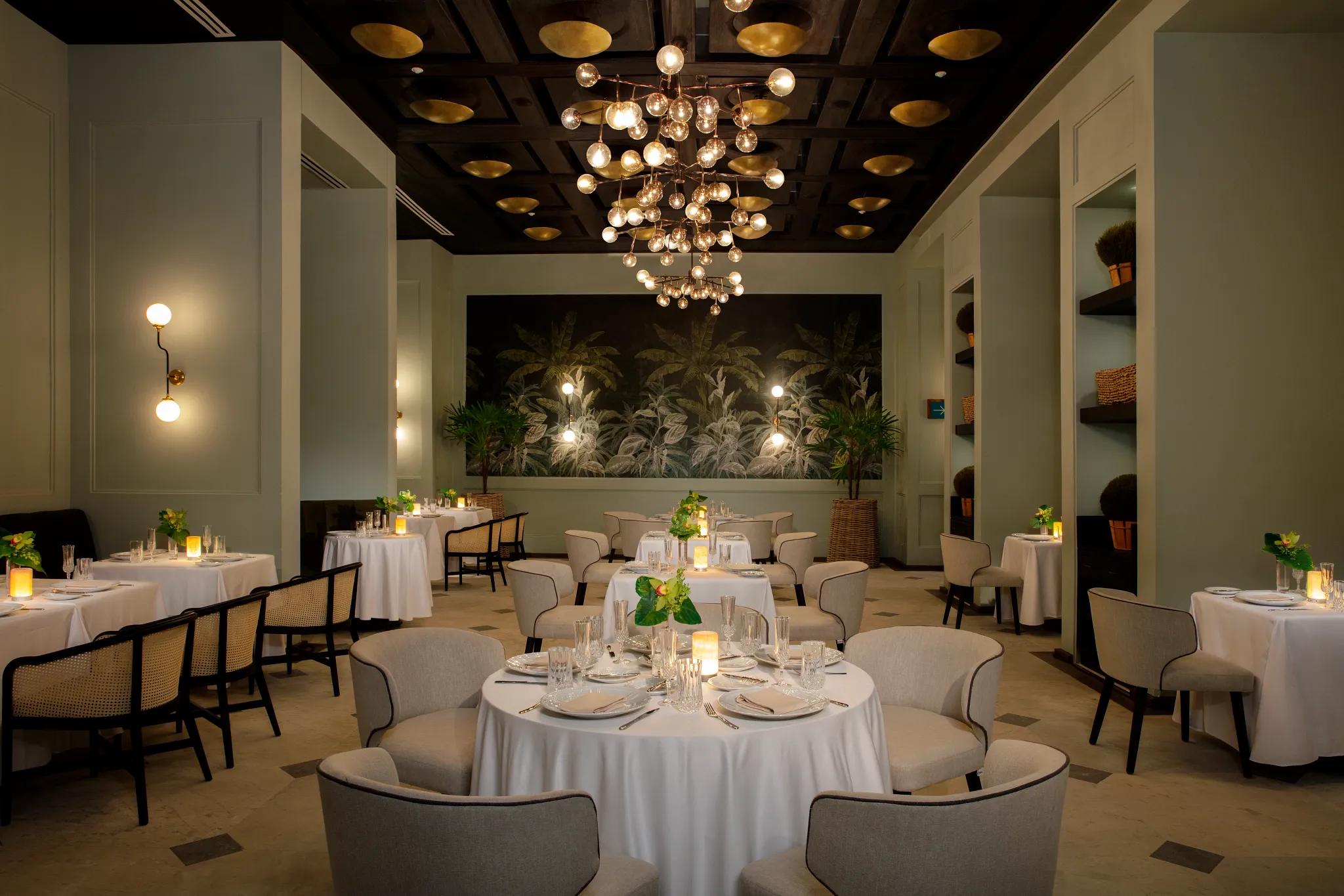 Bisou French restaurant at Secrets Moxché Playa del Carmen featuring elegant candlelit tables, modern chandeliers, and a sophisticated dining room.