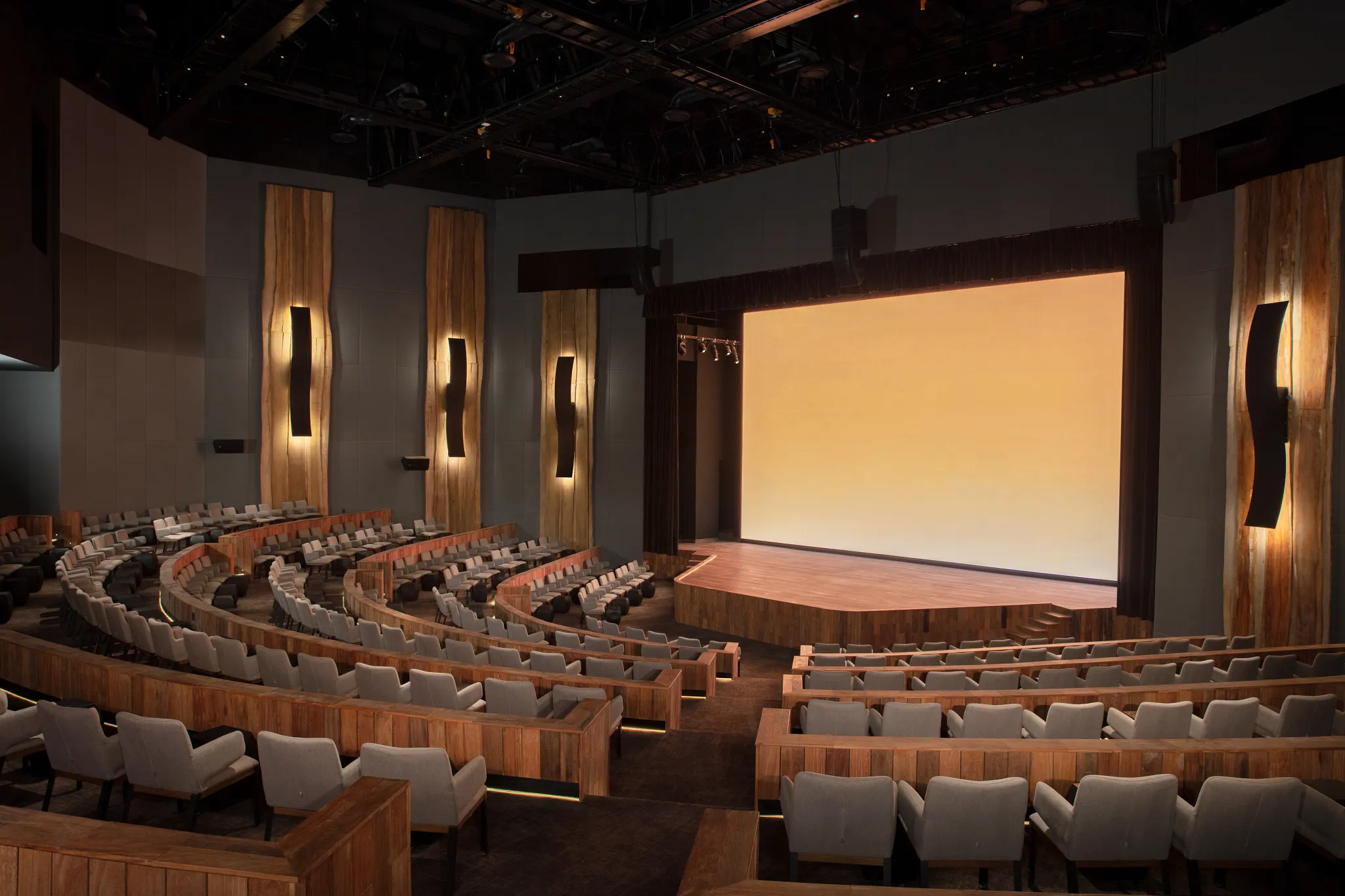 Modern theater with tiered seating and stage at Secrets Moxché Playa Del Carmen for nightly entertainment and shows.