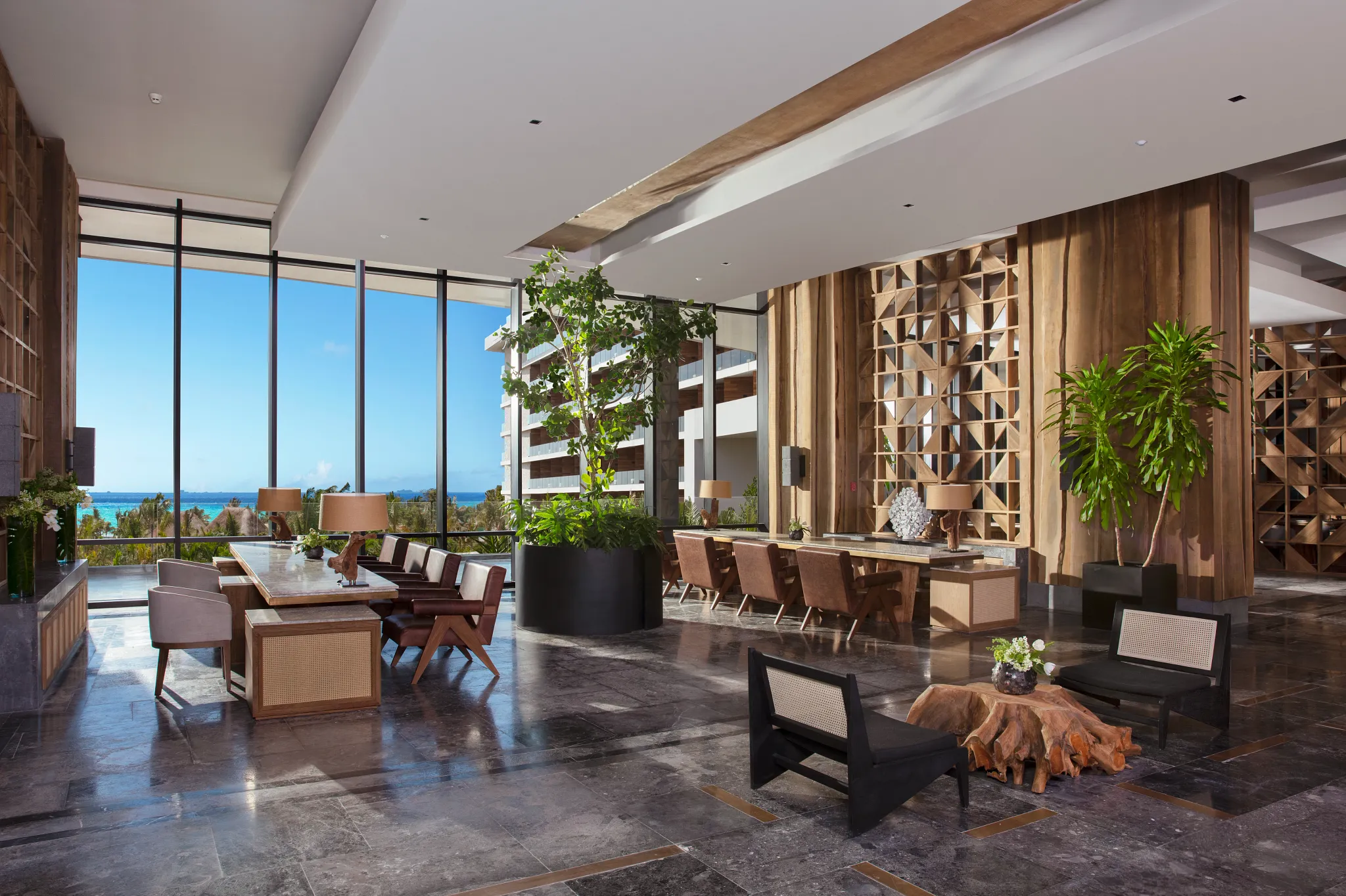 Modern lobby lounge with floor-to-ceiling windows and ocean views at Secrets Moxché Playa Del Carmen.
